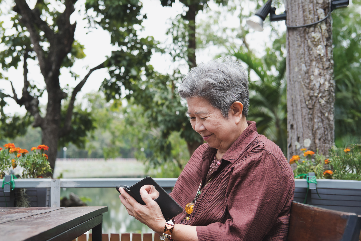 elderly woman using tablet outside